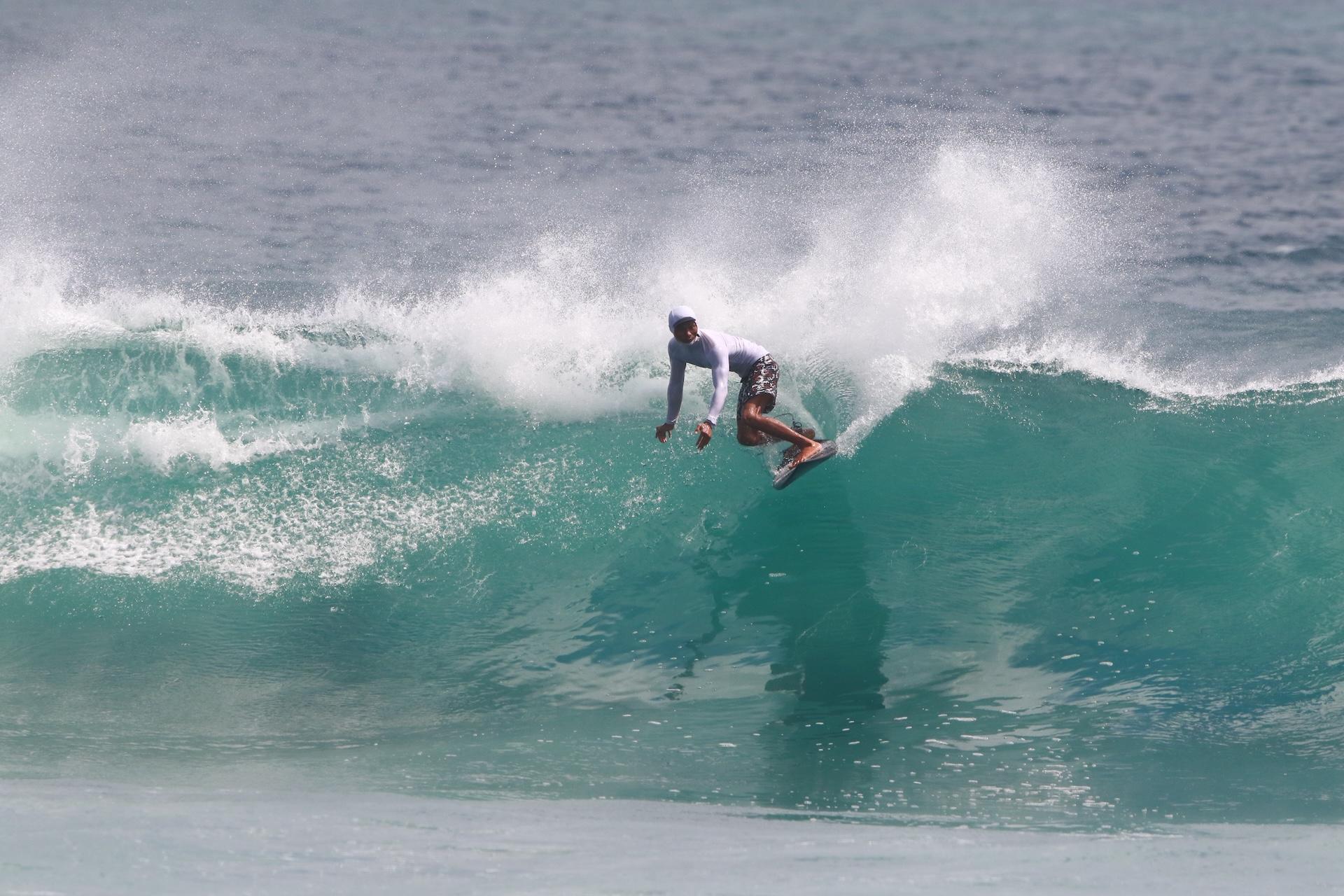 Arfas carving a turn on a turquoise wave